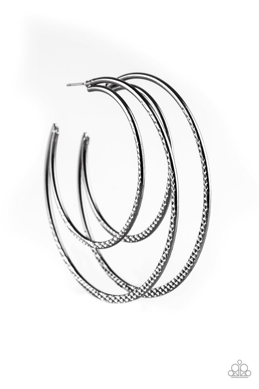 Paparazzi Accessories Drop It Like It’s HAUTE - Black Featuring diamond-cut textures, two glistening gunmetal bars curl into a bold hoop for a flawless finish. Earring attaches to a standard post fitting. Hoop measures 2 3/4” in diameter. Jewelry