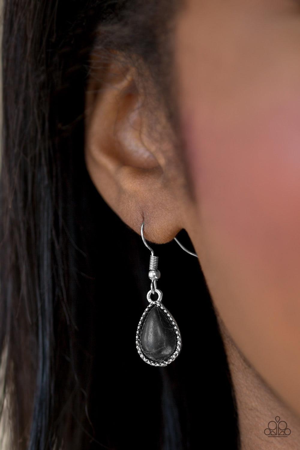 Paparazzi Accessories Sandstone Symphony - Black Chiseled into a tranquil teardrop, a polished black stone is pressed into a studded silver frame for a seasonal look. Earring attaches to a standard fishhook fitting. Jewelry