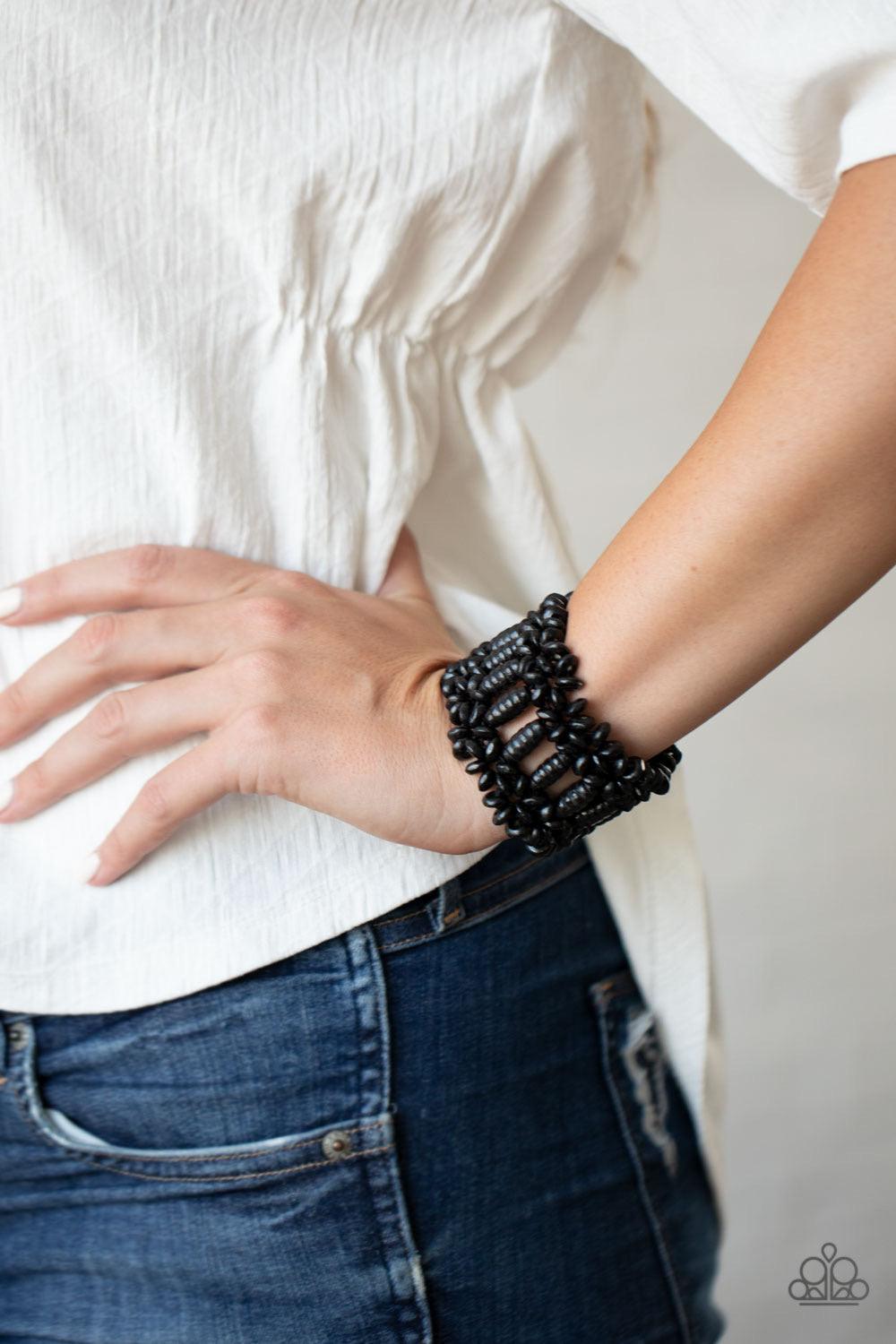 Paparazzi Accessories Fiji Flavor - Black Painted in a shiny black finish, round and oval wooden beads are threaded along stretchy bands that weave into a colorful floral patterned stretch bracelet around the wrist. Sold as one individual bracelet. Jewelr