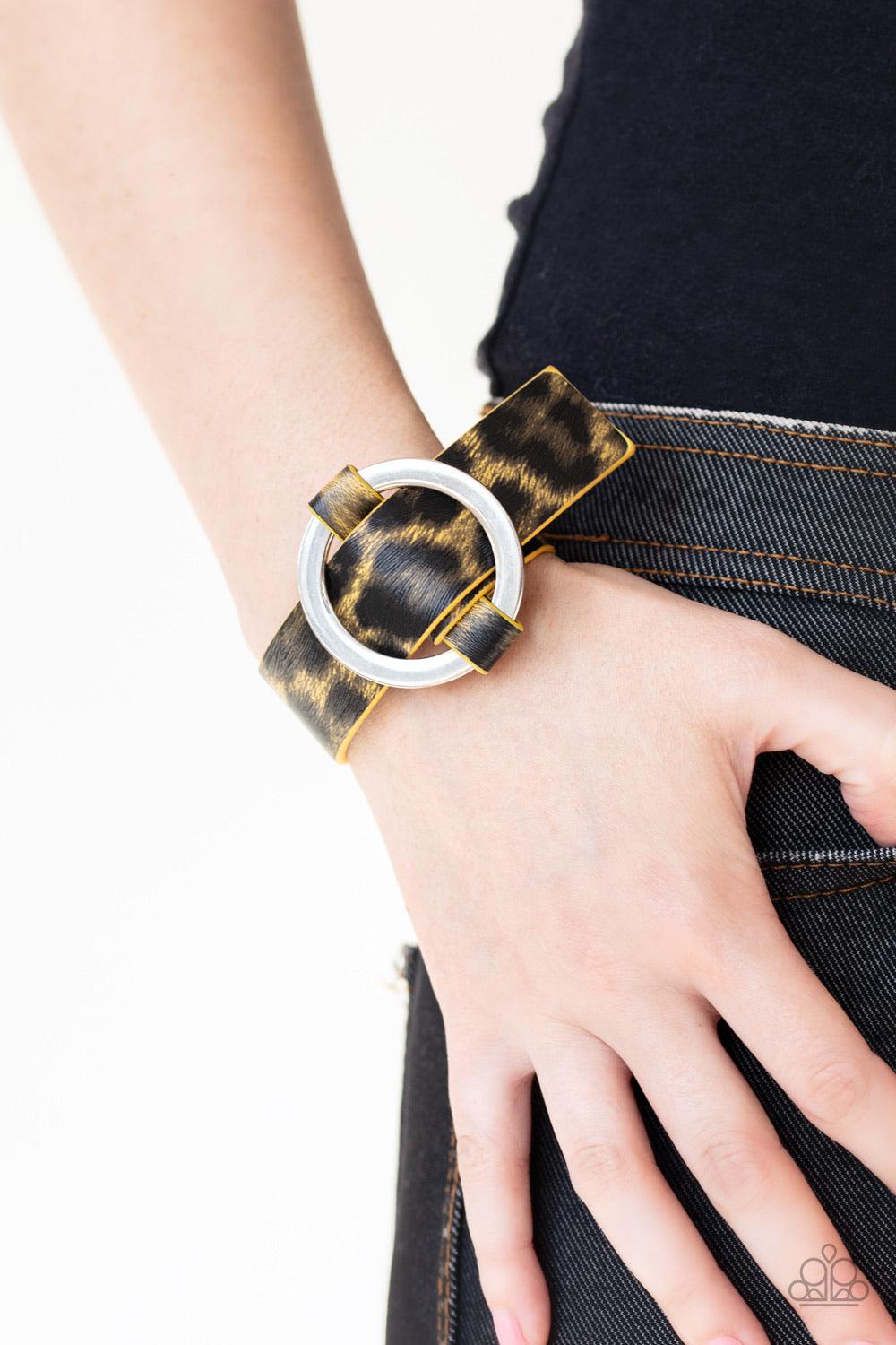 Paparazzi Accessories Jungle Cat Couture - Yellow Featuring a shiny yellow cheetah pattern, a textured piece of leather loops through the center of a shimmery silver hoop for a sassy urban look. Features an adjustable belt loop closure. Jewelry