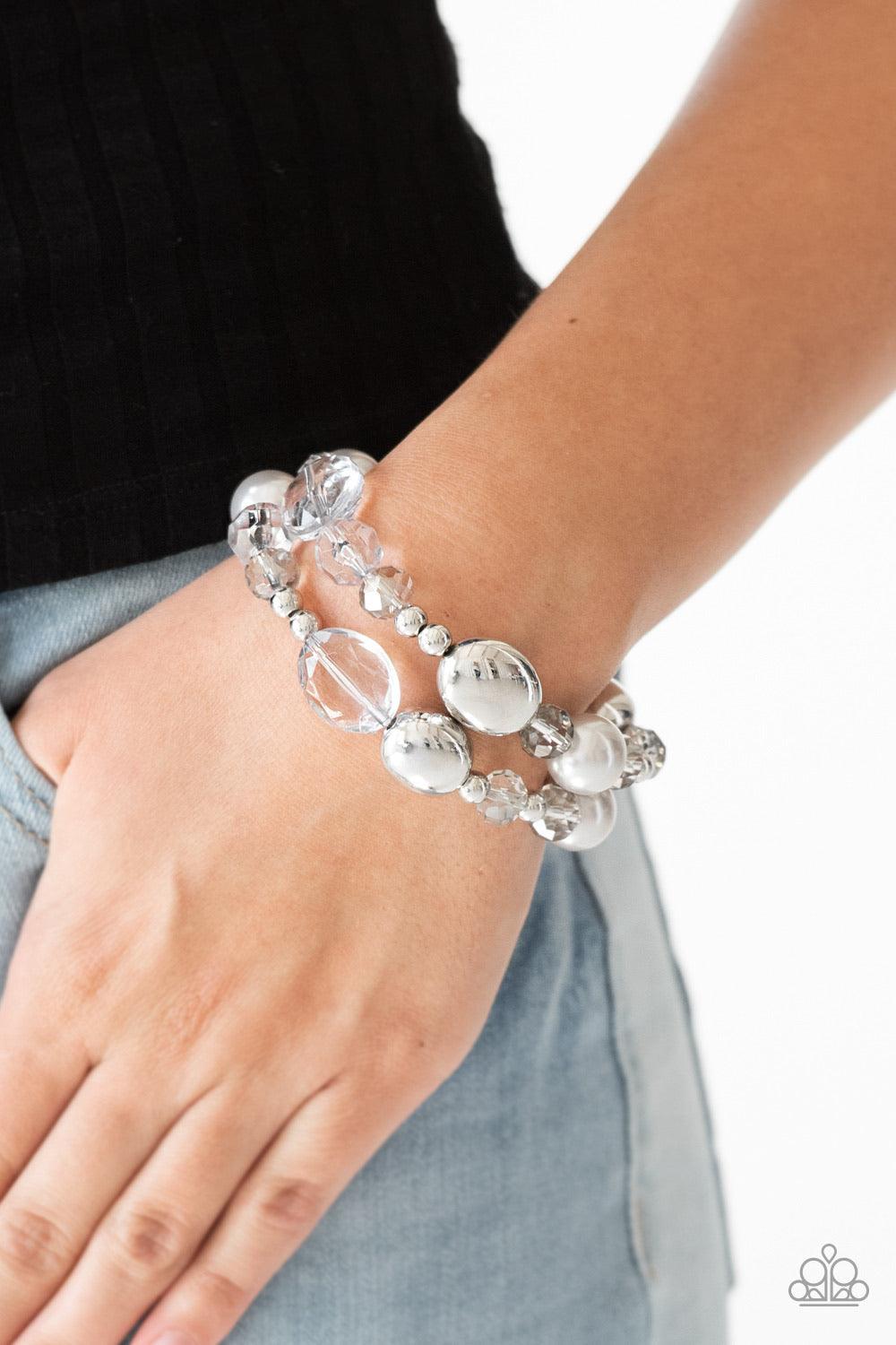 Paparazzi Accessories Downtown Dazzle - Silver An array of silver pearls, shiny silver beads, and smoky crystal-like beads are threaded along stretchy bands around the wrist for a refined look. Sold as one set of two bracelets. Jewelry