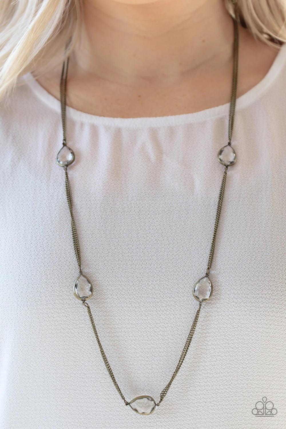Paparazzi Accessories Teardrop Timelessness - Brass Glassy white teardrops attach to sections of antiqued brass chain across the chest, creating a refined display. Features an adjustable clasp closure. Jewelry
