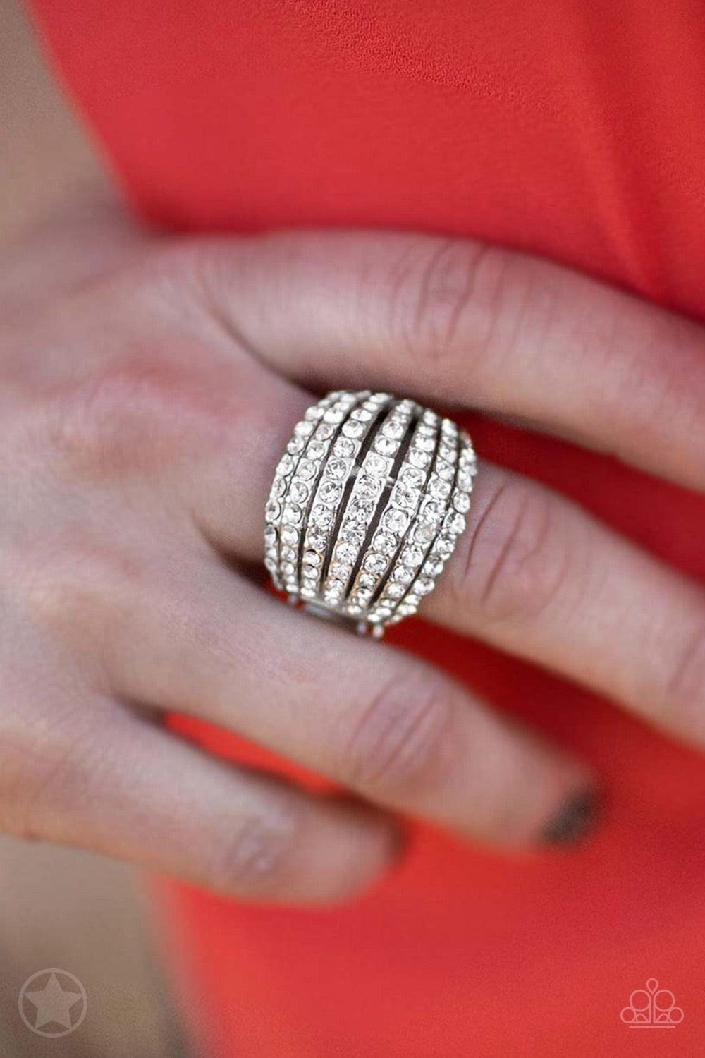 Paparazzi Accessories Blinding Brilliance - White Row after row of incandescent white rhinestones stack into a dazzling display. The gorgeous rounded bands and undeniable sparkle create a regal statement piece. Features a stretchy band for a flexible fit.