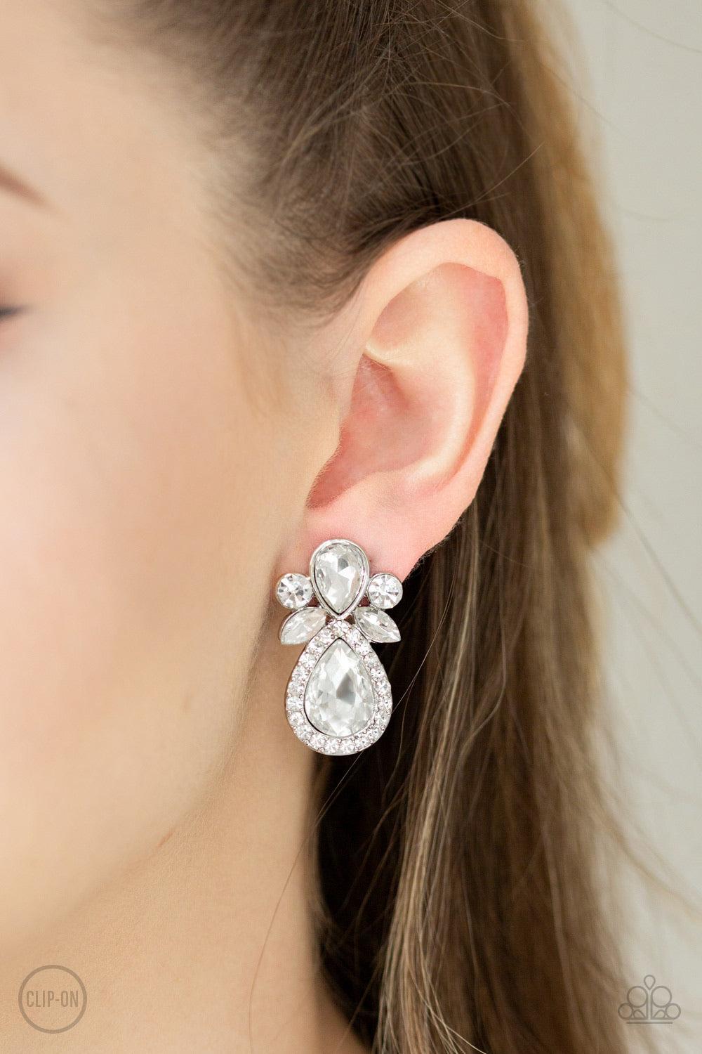 Paparazzi Accessories Celebrity Crowd - White *Clip-On A regal collection of marquise, teardrop, and classic round style cut white rhinestones coalesce into a glamorous frame. Earring attaches to a standard clip-on fitting. Jewelry