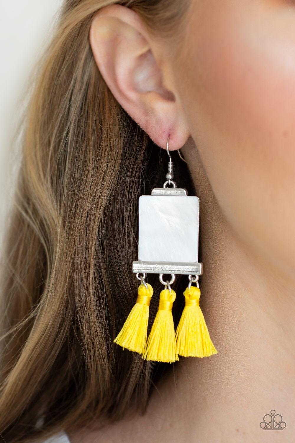 Paparazzi Accessories Tassel Retreat - Yellow A rectangular shell-like accent is nestled into a shiny silver frame. A trio of shiny yellow threaded tassels swing from the bottom of the incandescent frame for a flirtatious finish. Earring attaches to a sta