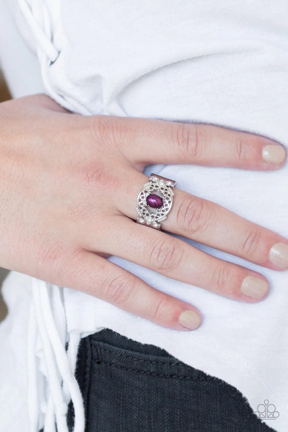 Paparazzi Accessories Mod Modest - Purple Dotted with glittery white rhinestones, an airy filigreed silver band arcs across the finger in a regal fashion. A pearly purple bead is pressed into the center of the band for a timeless finish. Features a stretc