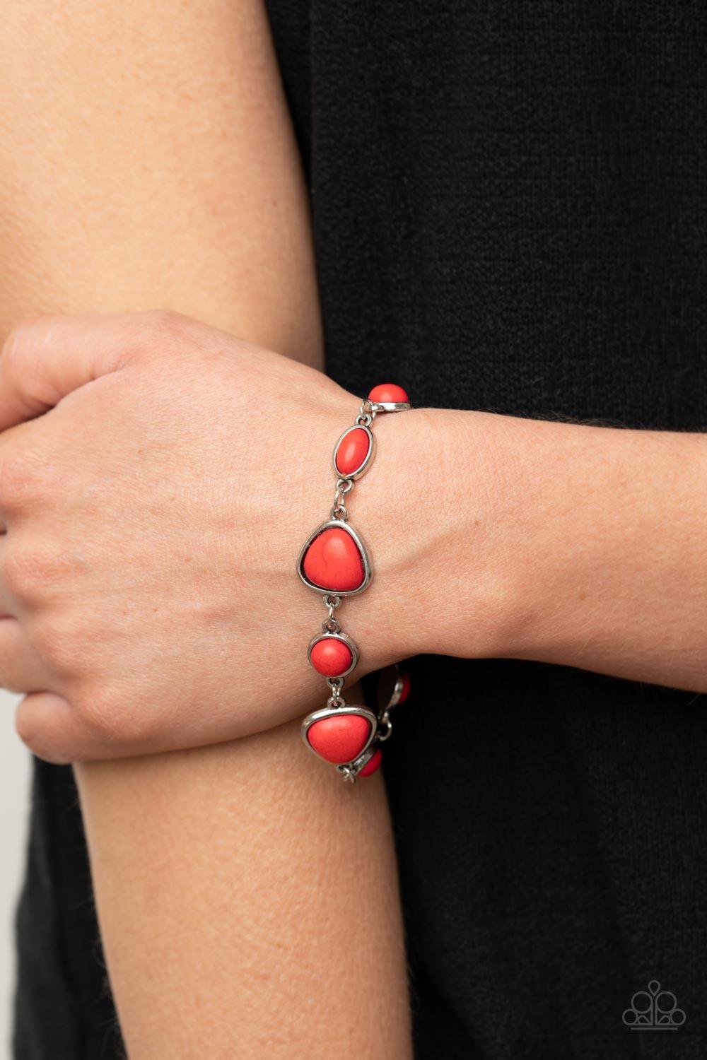 Paparazzi Accessories Eco-Friendly Fashionista - Red Encased in sleek silver frames, a collection of round, oval, and triangular red stones delicately link around the wrist for a one-of-a-kind look with an artisan feel. Features an adjustable clasp closur