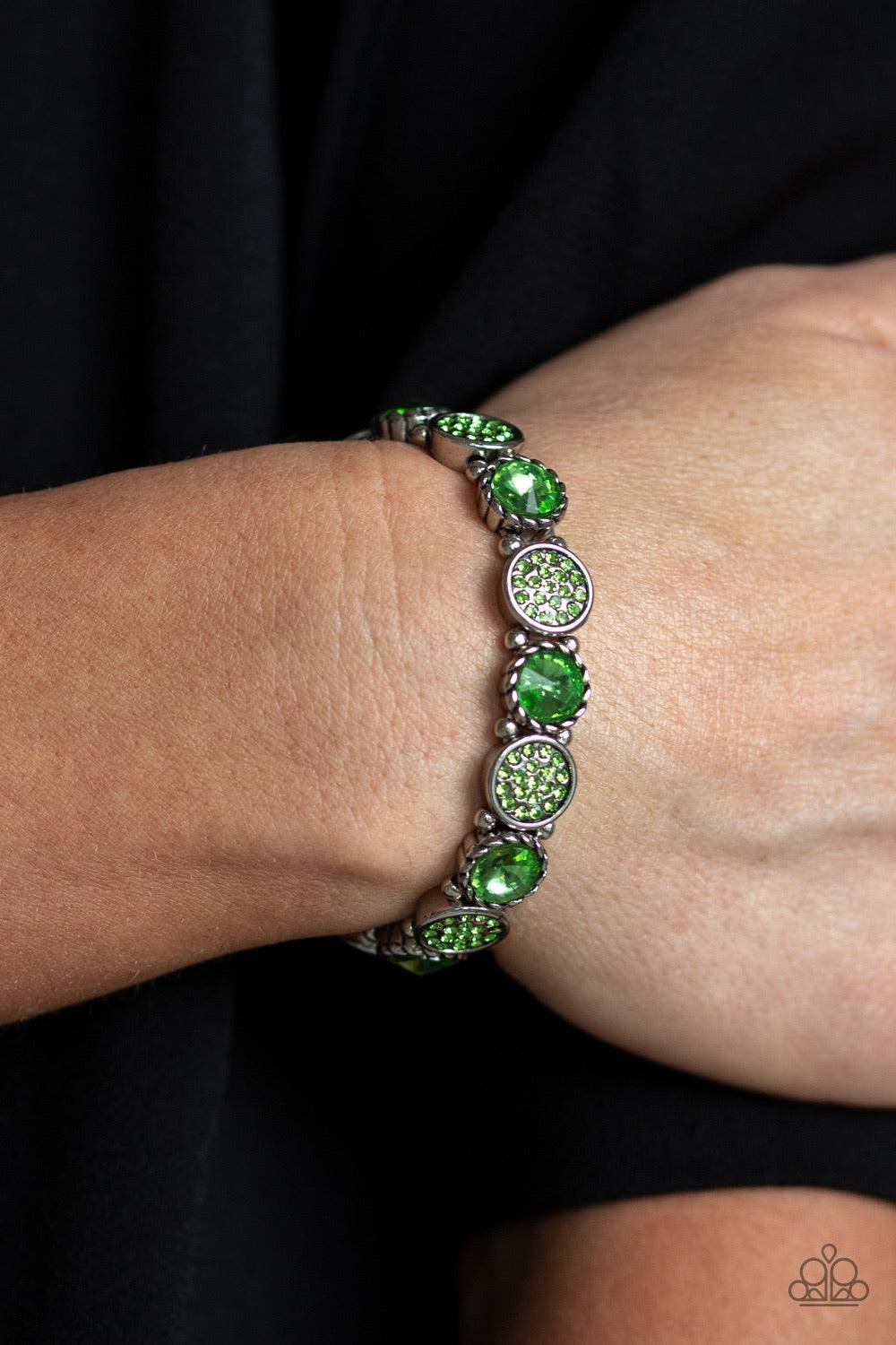 Paparazzi Accessories Take A Moment to Reflect - Green Featuring an array of glittery green rhinestones, mismatched silver frames and dainty silver beads are threaded along stretchy bands around the wrist for a glamorous flair. Jewelry