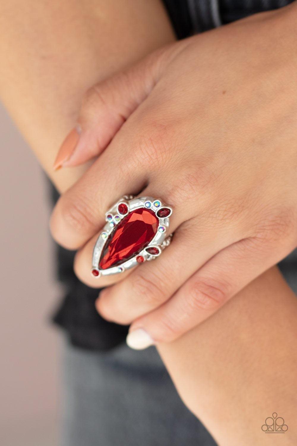 Paparazzi Accessories Sparkle Smitten - Red Varying in color and shape, mismatched red iridescent rhinestones sporadically dot the front of a shiny silver teardrop frame. Featuring a flashy faceted surface, an oversized red teardrop gem adorns the center