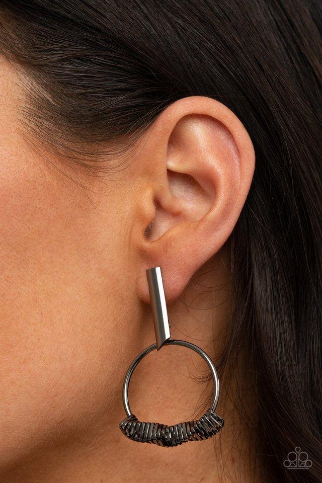Paparazzi Accessories Set Into Motion - Black Glistening gunmetal triangular rings are delicately fitted in place along the bottom of a dainty gunmetal hoop, creating the illusion of twisting movement. The edgy hoop links to a gunmetal rectangular hoop, c