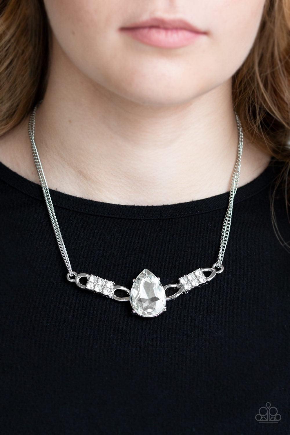 Paparazzi Accessories Way To Make An Entrance - White Cut into an alluring teardrop, an oversized white rhinestone gem attaches to bold silver frames radiating with glassy white rhinestones. The dramatic pendant attaches to doubled silver chains, swinging