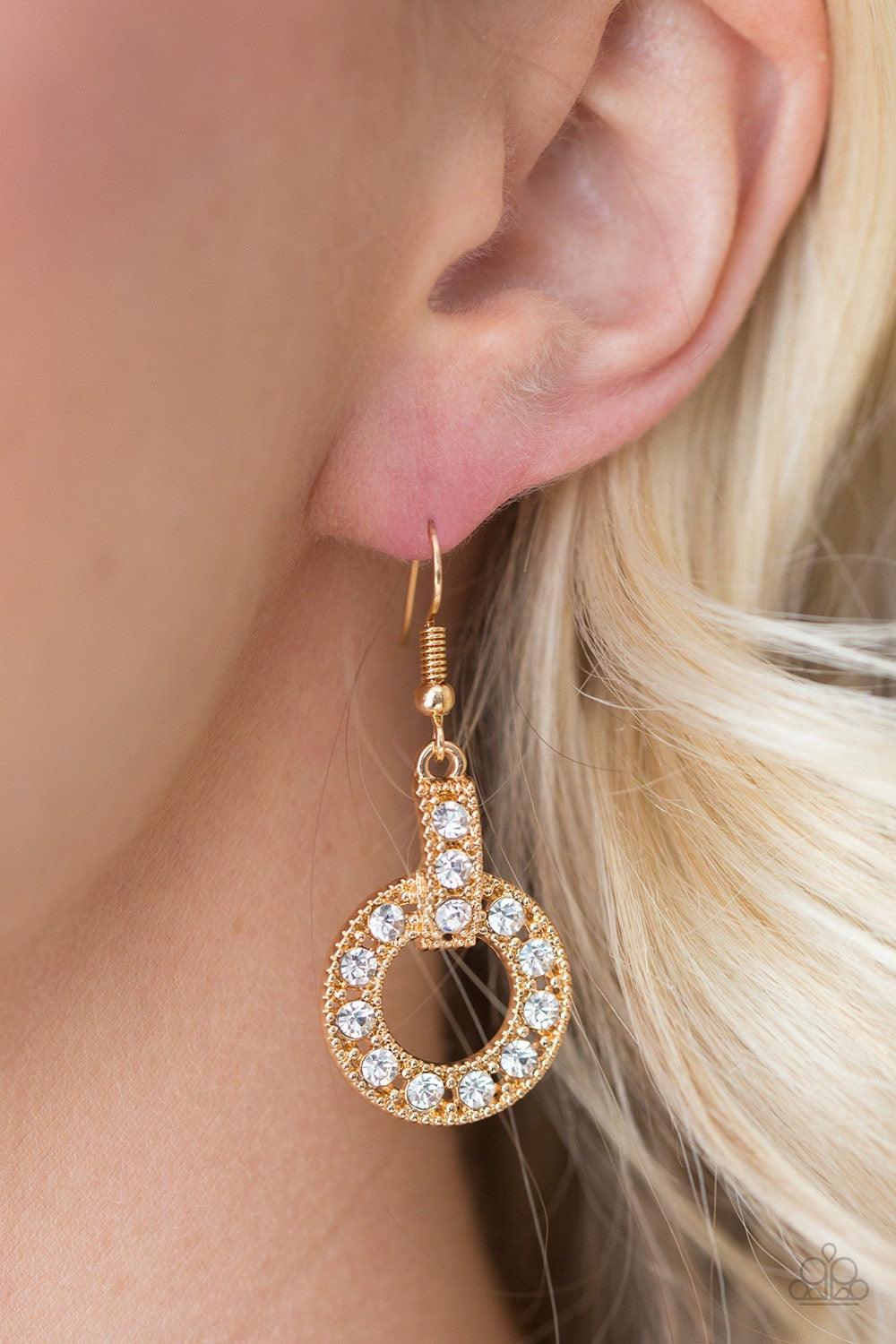 Paparazzi Accessories Midnight Ball - Gold Glittery white rhinestones are encrusted along a shimmery gold hoop and frame, creating an elegant lure. Earring attaches to a standard fishhook fitting. Jewelry