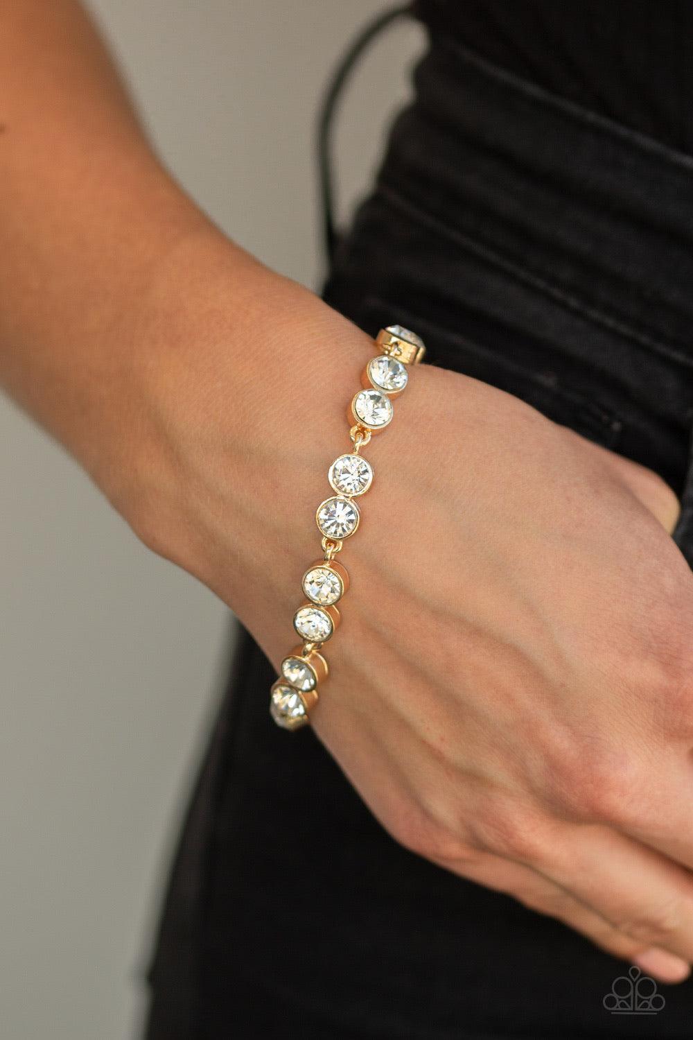 Paparazzi Accessories By All Means - Gold Encased in sleek gold frames, pairs of glittery white rhinestones link around the wrist for a timeless look. Features an adjustable clasp closure Jewelry