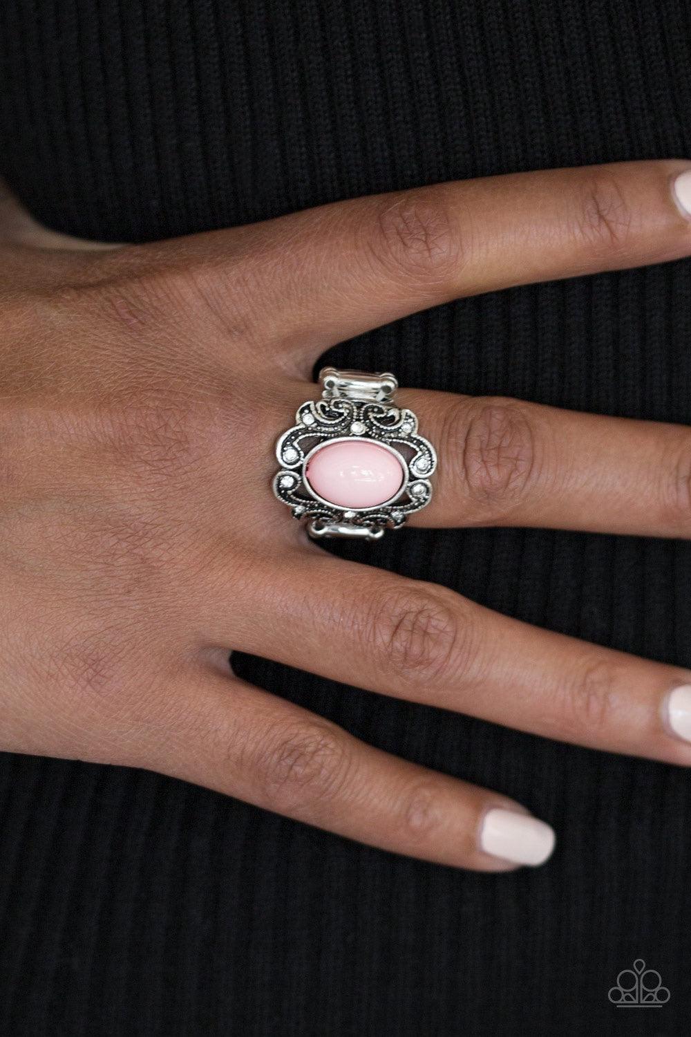 Paparazzi Accessories Pasadena Princess - Pink A pink bead is pressed into the center of a regal silver frame. Dazzling white rhinestones are sprinkled along fancy silver filigree, creating a stunning band. Features a stretchy band for a flexible fit. Jew