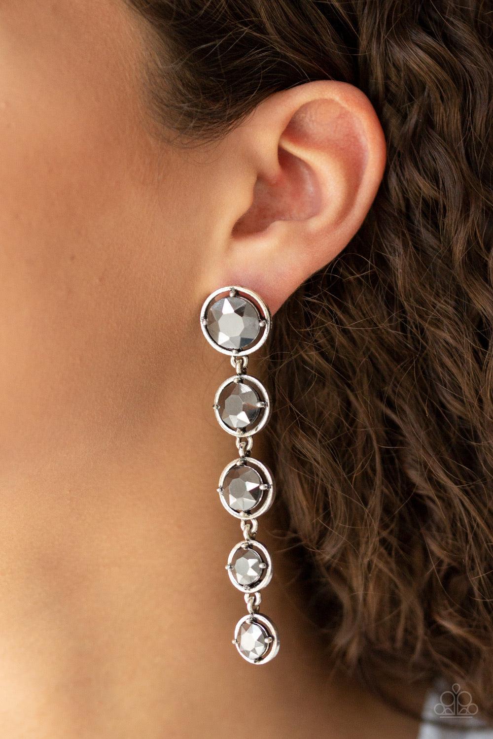 Paparazzi Accessories Dripping In Starlight - Silver Featuring sleek silver fittings, faceted hematite gems gradually decrease as they trickle from the ear for a glamorous look. Earring attaches to a standard post fitting. Jewelry