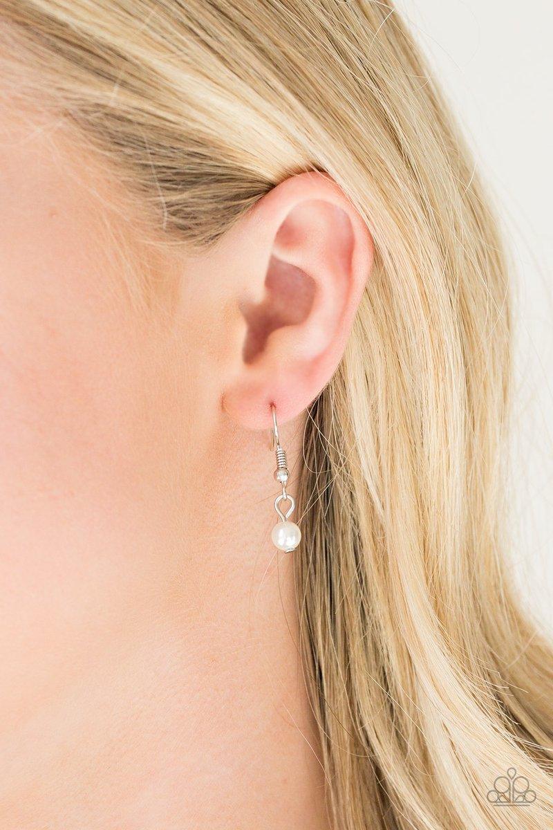 Paparazzi Accessories Be Fancy - White A solitaire white pearl swings from the uppermost chain, giving way to a teardrop pendant and shimmery silver chain tassel. Dainty white rhinestones and white pearls collect at the bottom of the centermost pendant fo