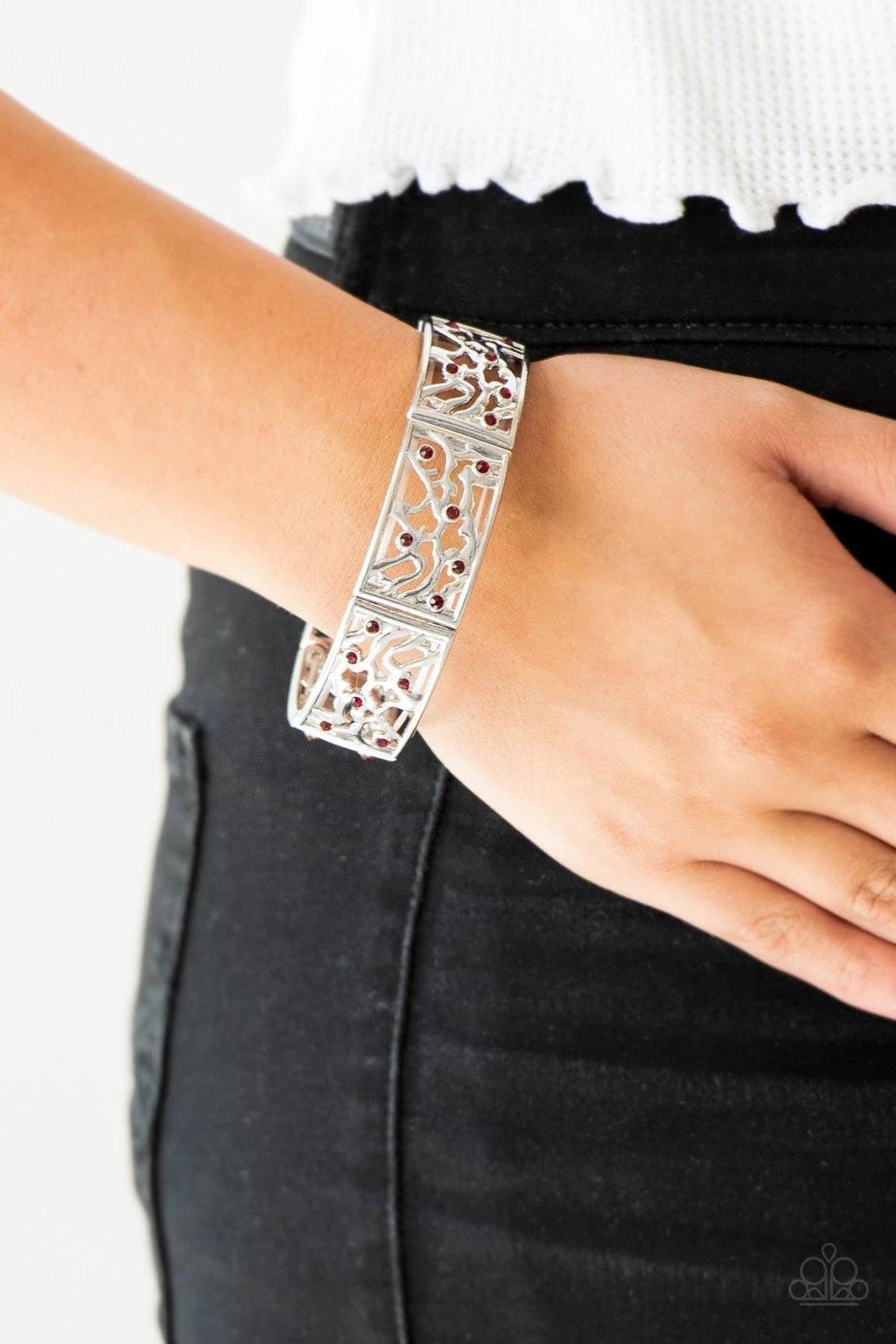 Paparazzi Accessories Yours and Vine - Red Filled with vine-like filigree, shimmery silver frames are threaded along stretchy bands around the wrist for a whimsical look. Dainty red rhinestones are sprinkled along the ornate frames for a sparkling finish.