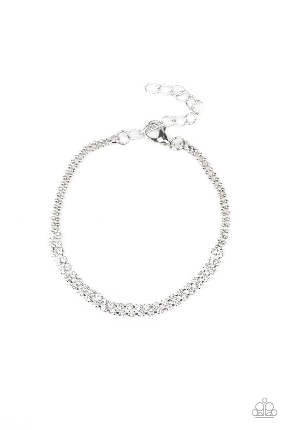 Paparazzi Accessories All Dolled Up - White Delicately coalescing into a solitaire centerpiece, two dainty silver ball chains attach to two rows of glassy white rhinestones across the wrist for a timeless look. Features an adjustable clasp closure. Jewelr