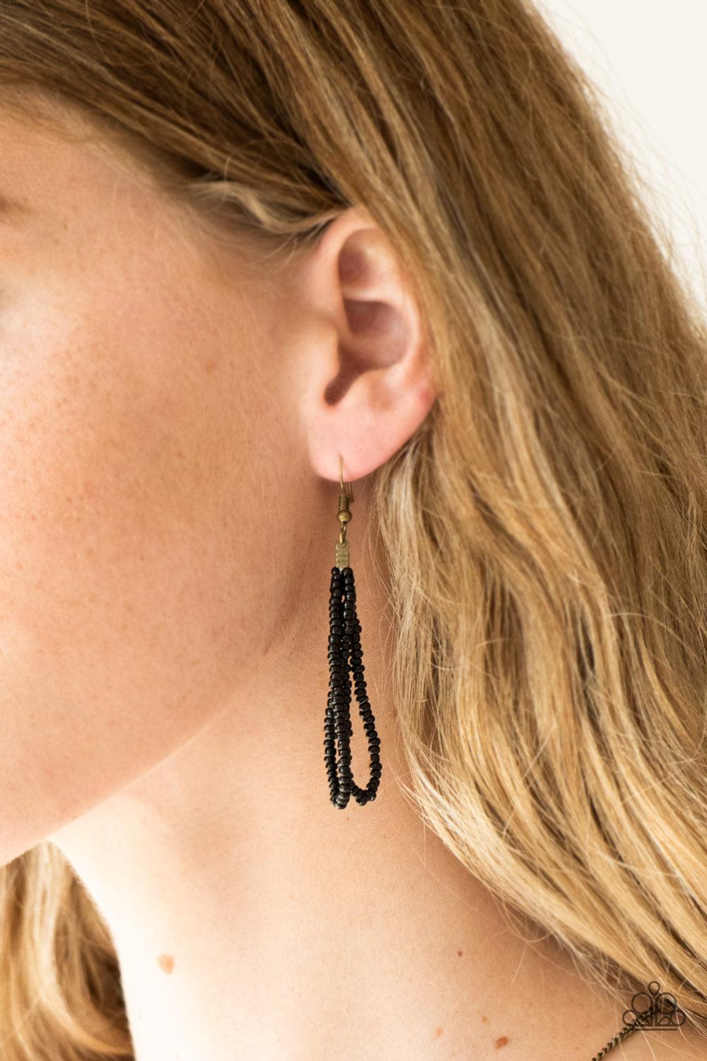 Paparazzi Accessories Badlands Beauty - Black Infused with black, brass, and brown seed beads, a colorful dream catcher like pendant swings from the bottom of a lengthened brass chain for a tribal inspired look. Features an adjustable clasp closure. Sold