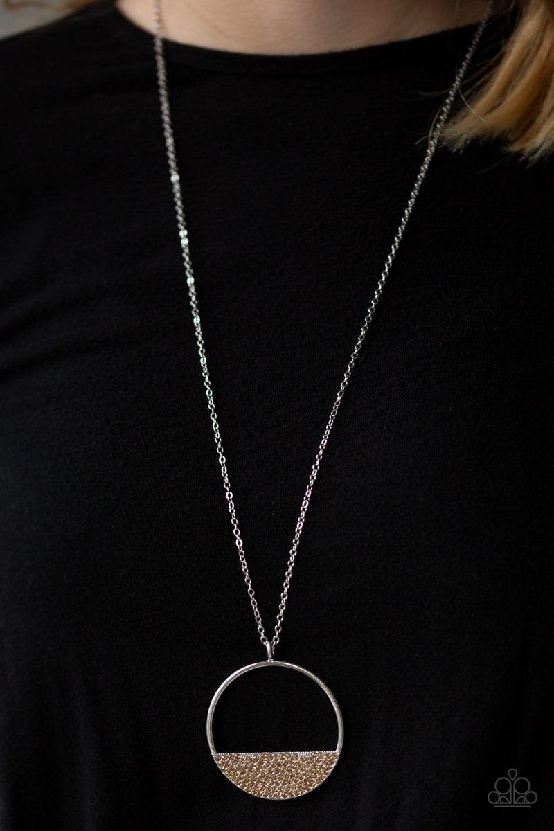 Paparazzi Accessories Set Your Bottom Dollar - Brown Encrusted in golden topaz rhinestones, a silver crescent frame is pressed into the bottom of an airy circular pendant for a timeless look. Features an adjustable clasp closure. Sold as one individual ne