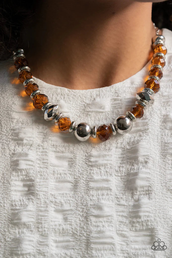 Paparazzi Accessories Interstellar Influencer - Brown A dramatic assortment of oversized silver beads, textured silver rings, and faceted brown crystal-like gems delicately glides along an invisible wire below the collar, resulting in a stellar sparkle. F