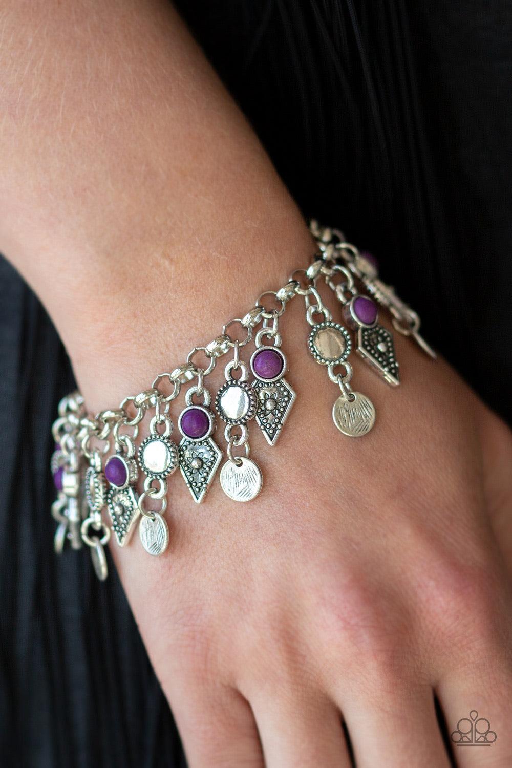 Paparazzi Accessories Triassic Trade Route ~Purple Featuring studded detail and vivacious purple stone accents, mismatched silver frames swing from the bottom of a bold silver chain, creating a flirty fringe around the wrist. Features an adjustable clasp