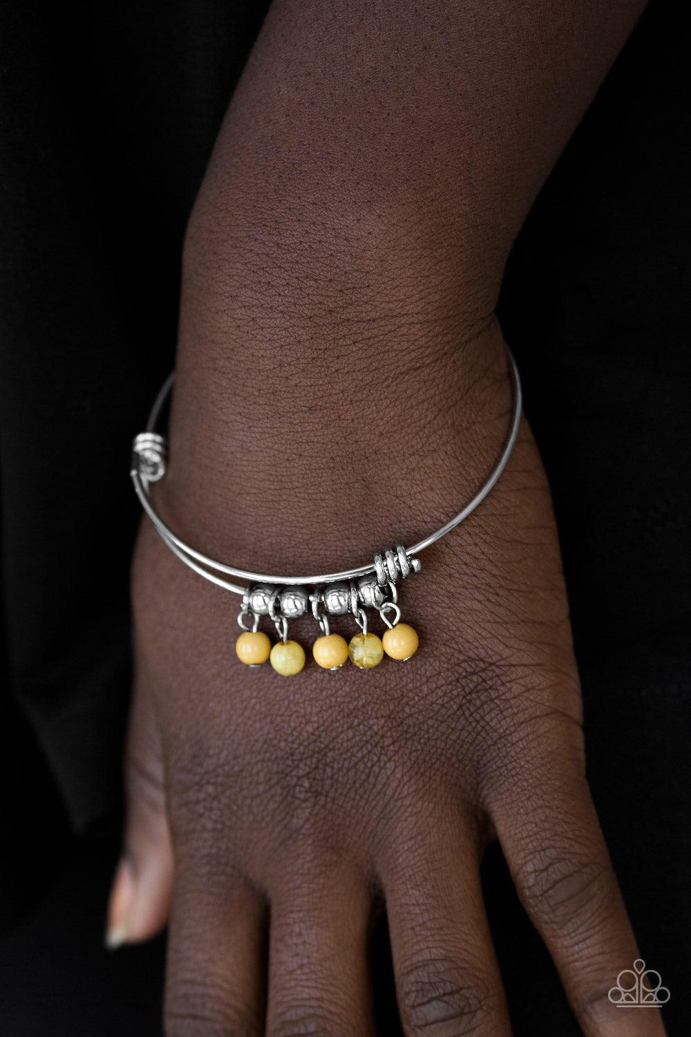Paparazzi Accessories All Roads Lead To ROAM - Yellow Silver wire coils around the wrist, creating an adjustable-like bangle. Glassy yellow beads slide between two wire wrap fittings, creating colorful accents along the wrist. Sold as one individual brace