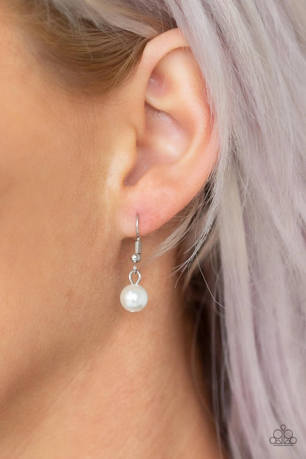 Paparazzi Accessories Out of Bounds Shimmer - White An airy circular pendant swings from the bottom of a lengthened silver chain. Infused with a solitaire white pearl swinging from the top of the frame, a fringe of white pearls and shimmery silver chains