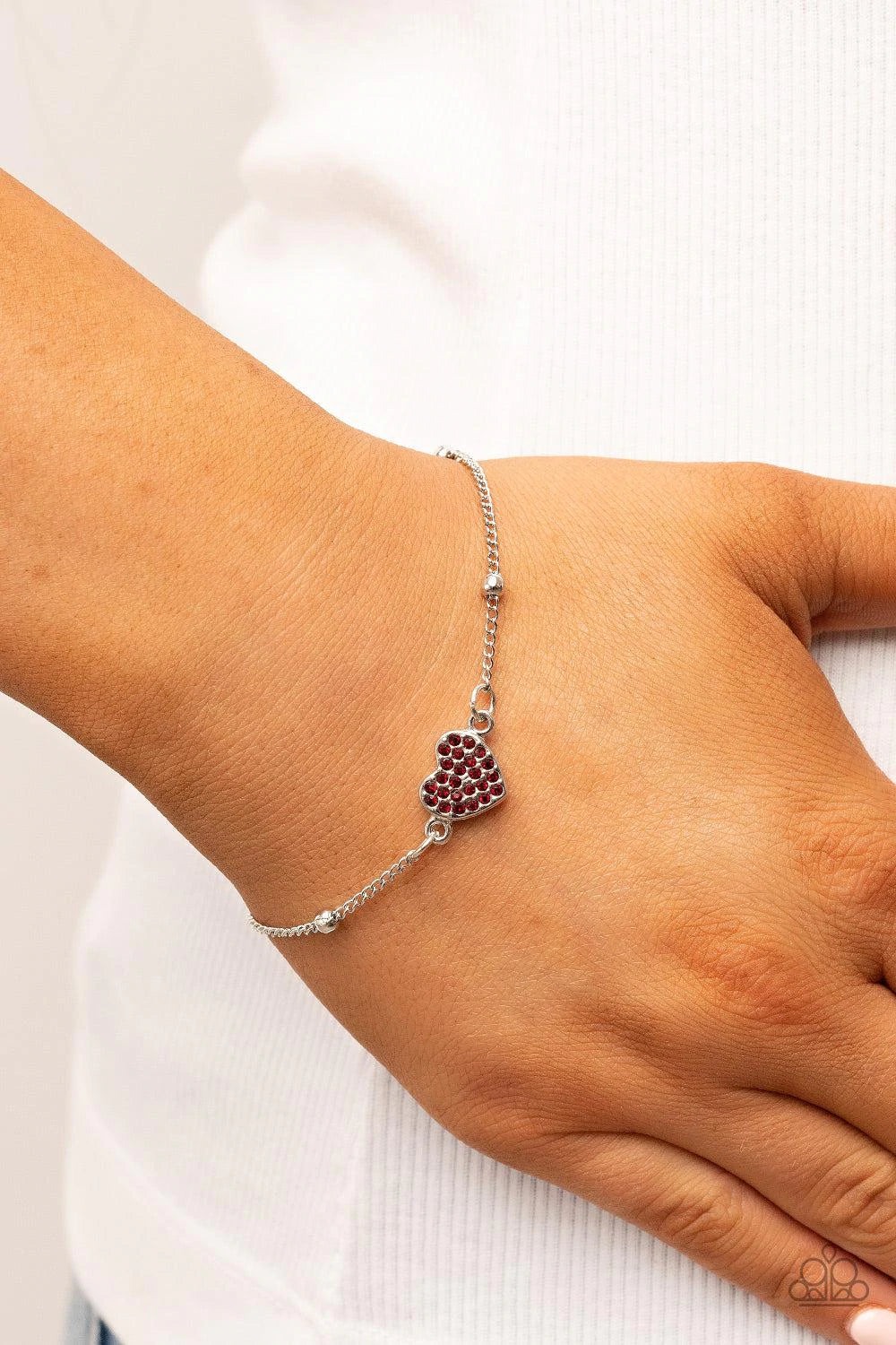Paparazzi Accessories Heartachingly Adorable - Red A red rhinestone dotted silver heart charm adorns a silver beaded chain, creating a romantic centerpiece. Features an adjustable clasp closure. Sold as one individual bracelet. Jewelry