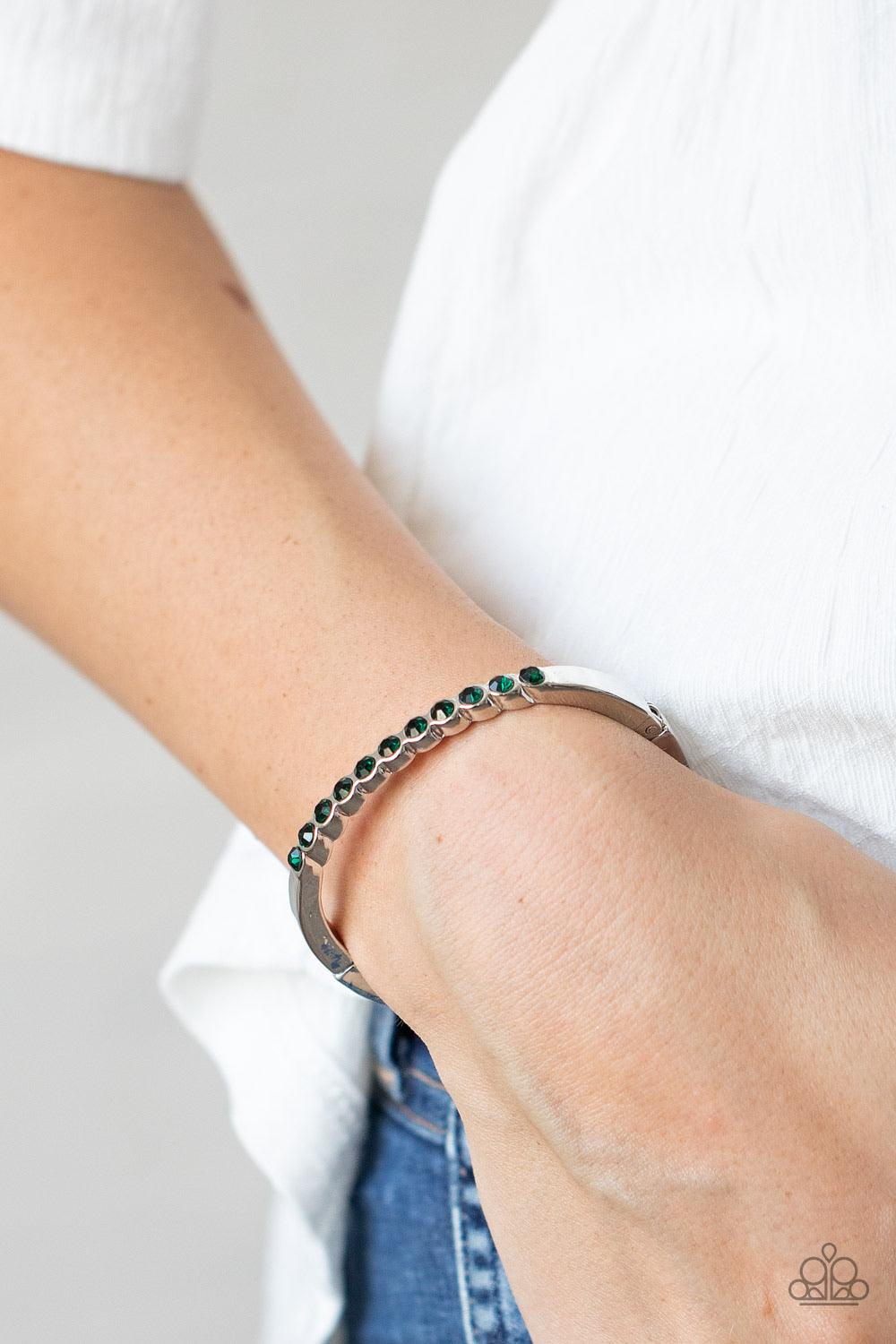 Paparazzi Accessories Stellar Beam ~Green A row of glittery green rhinestones is encrusted across the top of a dainty silver cuff-like bracelet for a gorgeous finish. Features a hinged closure. Sold as one individual bracelet. Jewelry