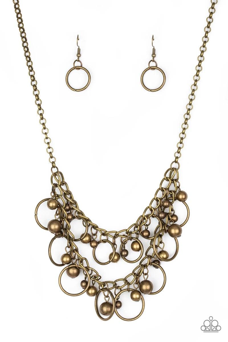 Paparazzi Accessories Warning Bells - Brass Brushed in an antiqued finish, mismatched brass beads and airy brass hoops swing from two rows of brass chains, creating an edgy fringe below the collar. Features an adjustable clasp closure. Sold as one individ