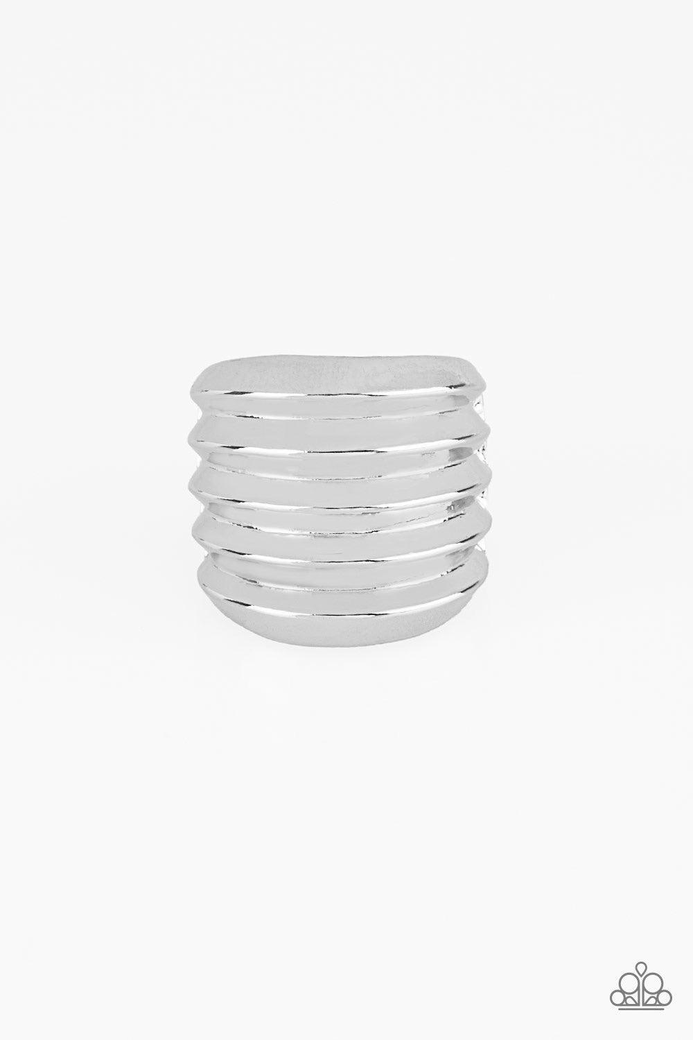 Paparazzi Accessories Hit Em Where It Hurts - Silver Rippling silver bands coalesce into a thick frame around the finger for a dramatic industrial look. Features a stretchy band for a flexible fit. Jewelry