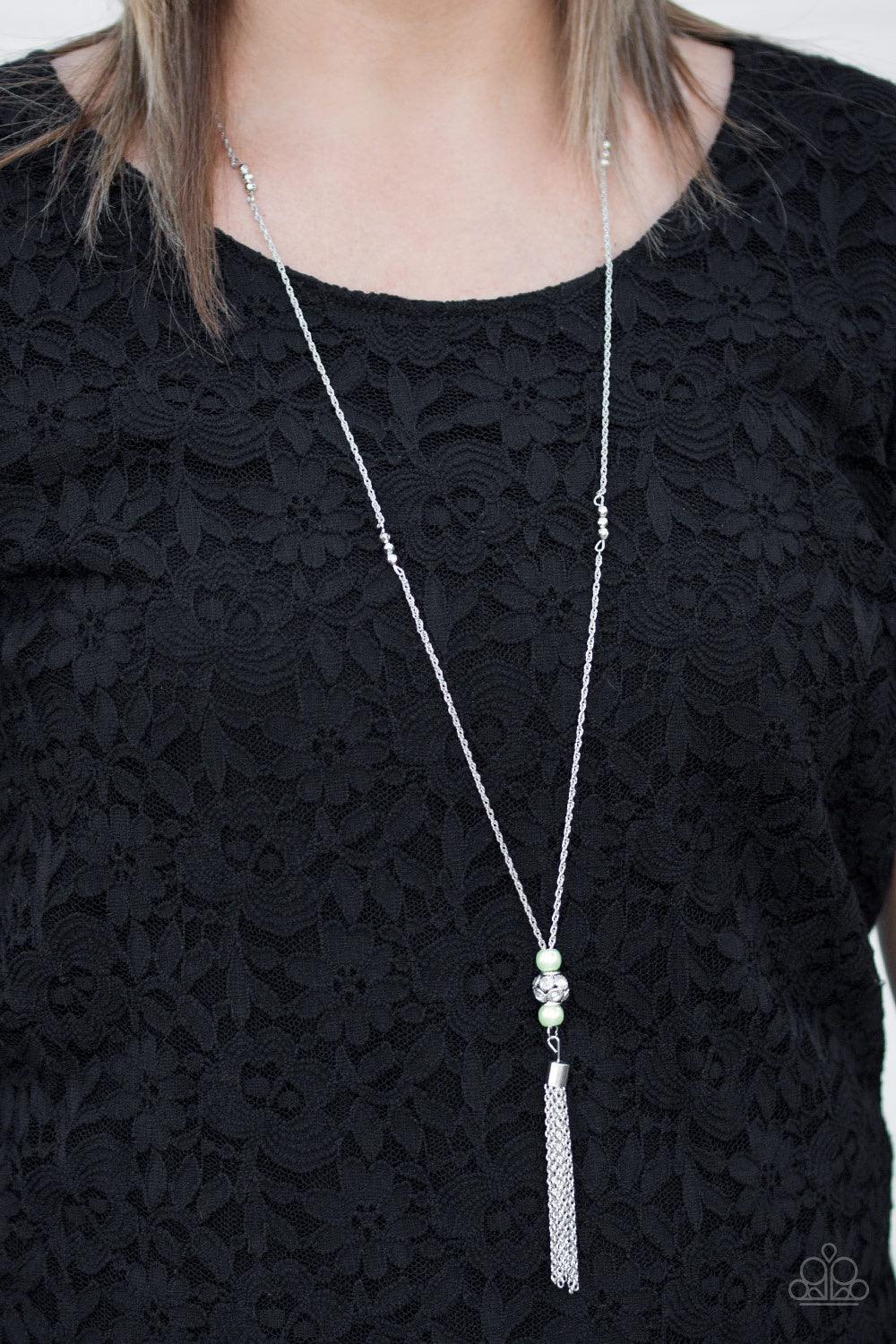 Paparazzi Accessories Century Shine - Green Infused with faceted silver accents, pearly green beads and a silver bead encrusted in glittery white rhinestones slide along a shimmery silver chain, creating an elegant centerpiece. A glistening silver tassel