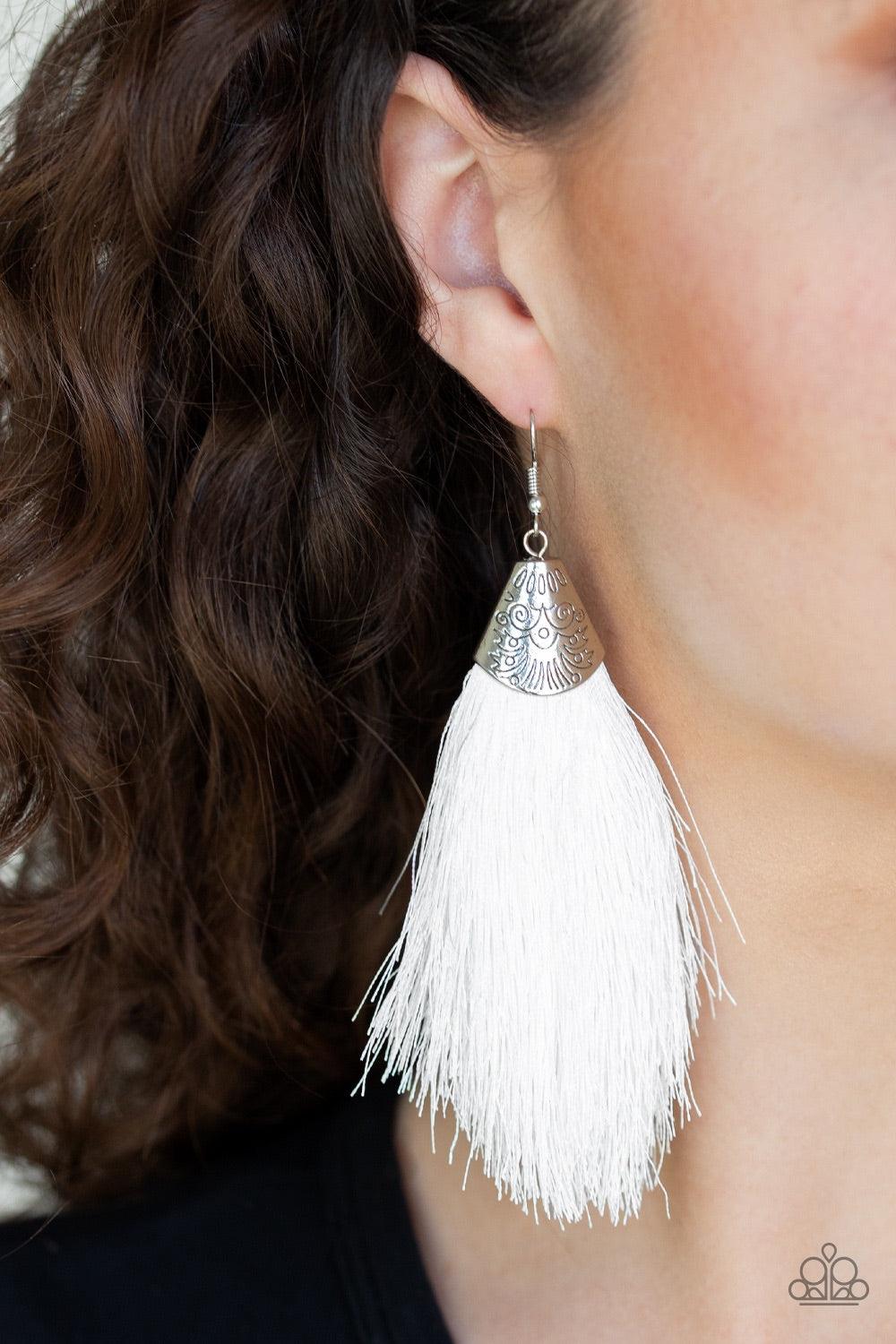 Paparazzi Accessories Tassel Temptress - White A plume of soft white thread is pinched between a shimmery silver fitting stamped in tribal inspired textures, creating a foxy tassel. Earring attaches to a standard fishhook fitting. Jewelry