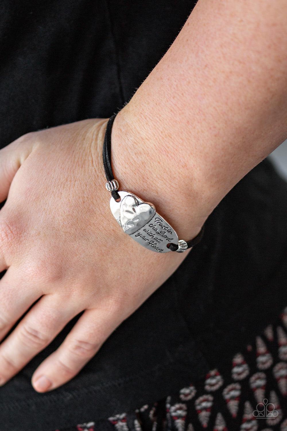 Paparazzi Accessories A Full Heart - Silver nfused with dainty silver beads, strands of black suede knot around a heart decorated frame that has been stamped in the inspirational phrase, "Trust In The Lord With All Your Heart". Features an adjustable clas