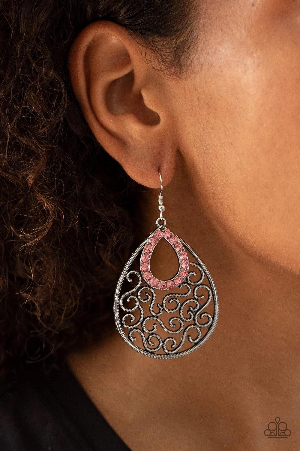 Paparazzi Accessories Seize The Stage - Pink A glittery pink rhinestone teardrop frame nestles at the top of an antiqued silver teardrop filled with whimsical vine-like filigree. Earring attaches to a standard fishhook fitting. Sold as one pair of earring
