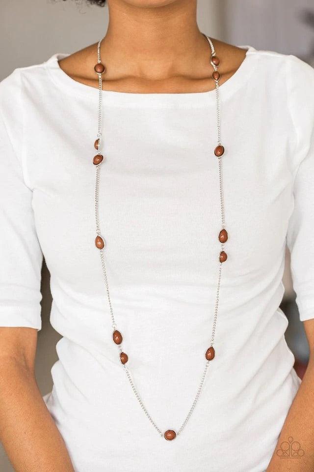 Paparazzi Accessories Pacific Piers - Brown Featuring round and teardrop shapes, brown beading trickles along an elongated silver chain for a seasonal look. Features an adjustable clasp closure. Sold as one individual necklace. Includes one pair of matchi