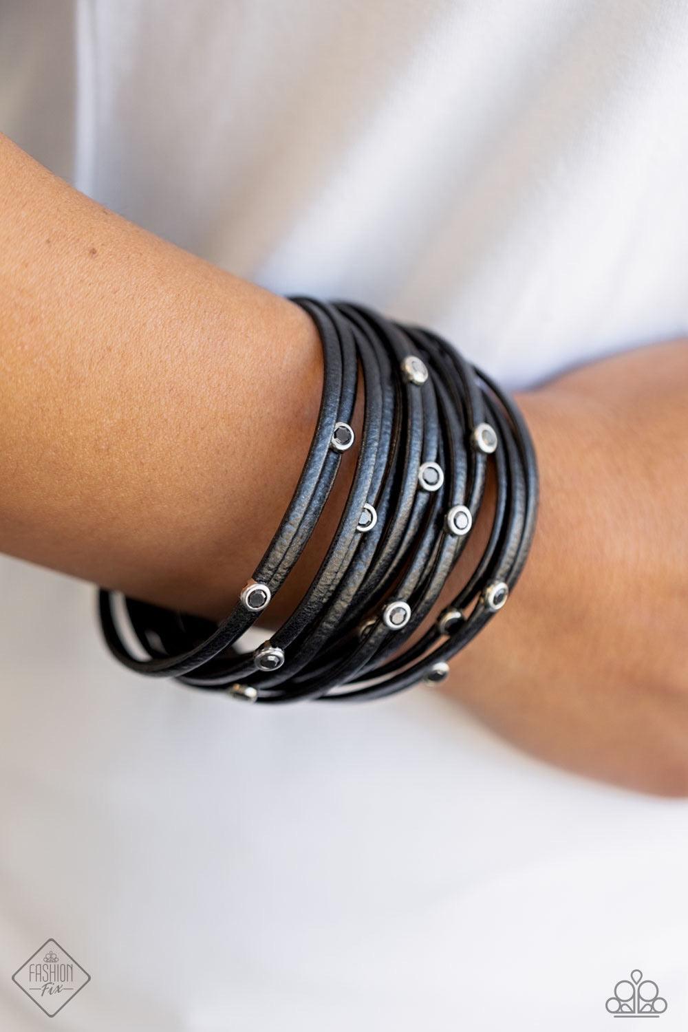 Paparazzi Accessories Fearlessly Layered ~Black Dotted with smoky hematite rhinestones, strands of black leather cording are strung between two silver fittings around the wrist in a fabulously layered finish. Features a magnetic closure. Sold as one indiv