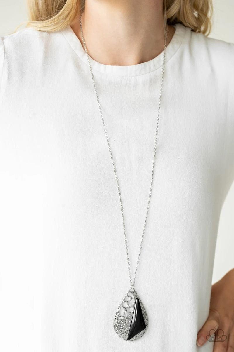 Paparazzi Accessories Impressive Edge - Black Featuring a triangular shape, a shiny black bead is pressed into a hammered silver teardrop radiating with airy cut-out patterns for an edgy look. The impressive pendant swings from the bottom of a lengthened