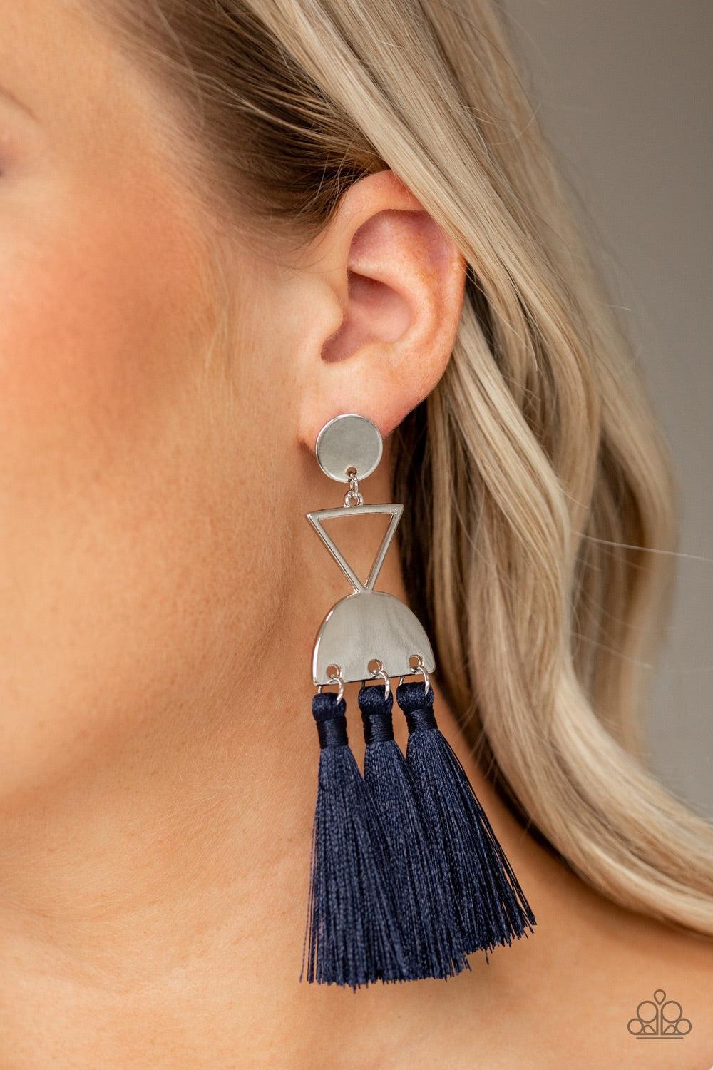 Paparazzi Accessories Tassel Trippin - Blue A shimmery silver disc, airy silver triangle, and shimmery half moon frame link into a geometric lure. Three blue threaded tassels swing from the bottom of the stacked frame for a trendy finish. Earring attaches