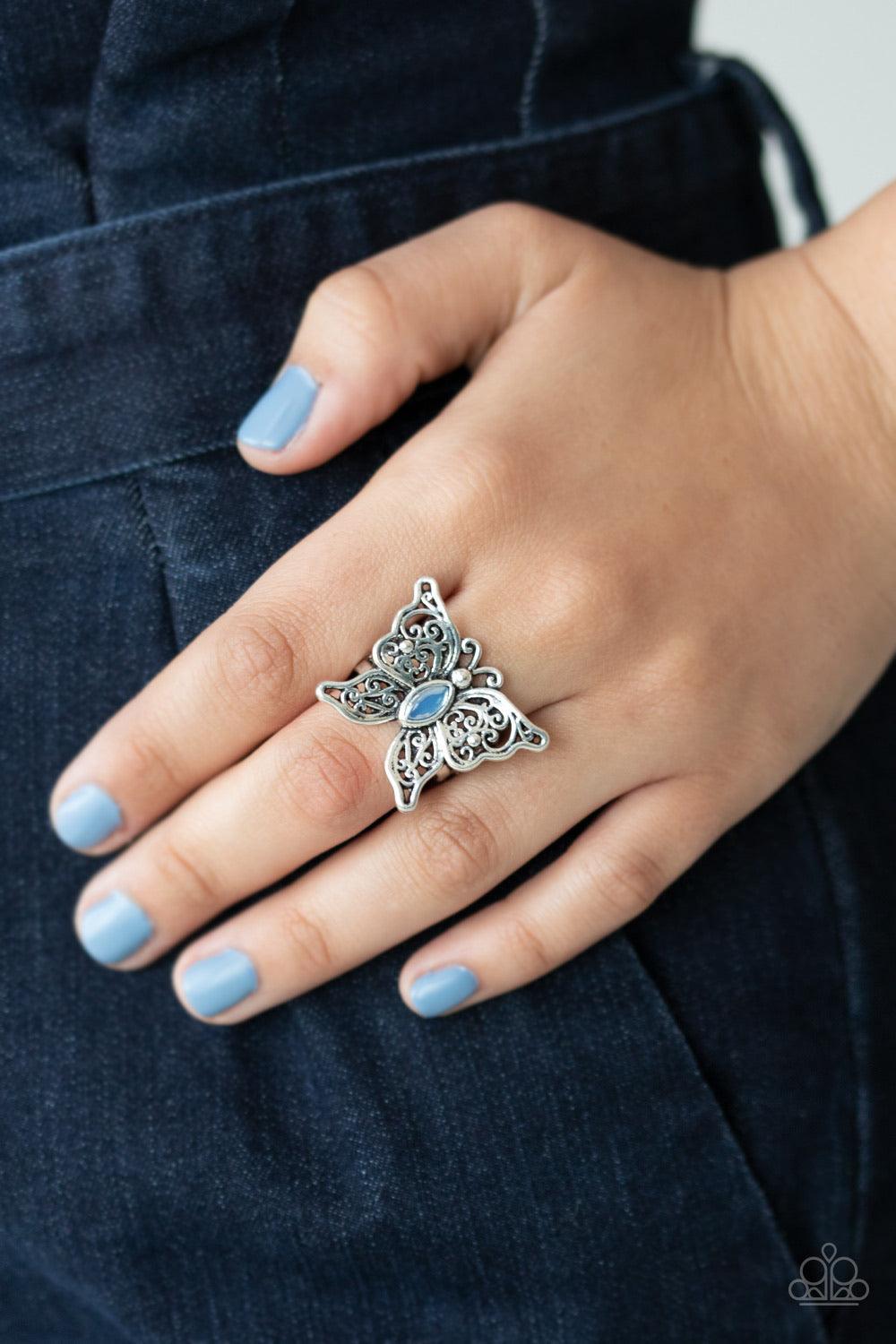 Paparazzi Accessories Flutter Flavor - Blue Lacy silver wings bloom from an opalescent blue cat's eye center, coalescing into a whimsical butterfly atop the finger. Features a stretchy band for a flexible fit. Sold as one individual ring. Jewelry