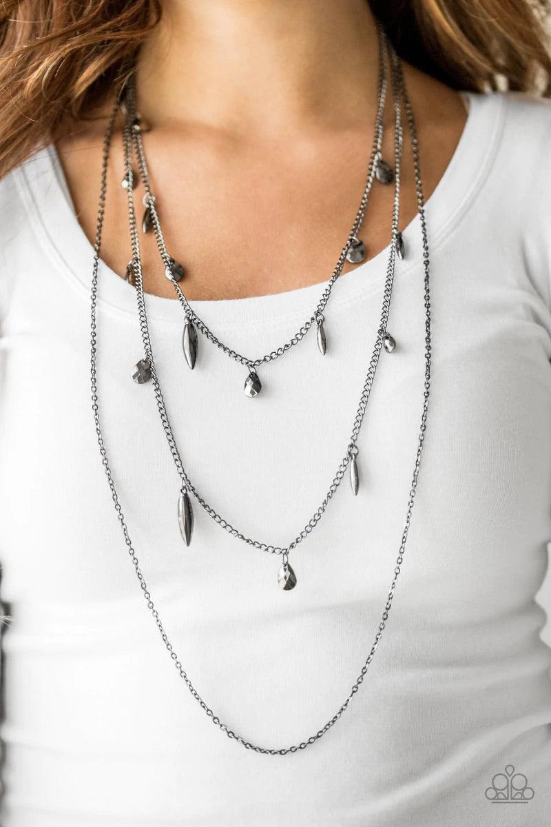 Paparazzi Accessories Bravo Bravado - Black Mismatched gunmetal chains layer down the chest. Faceted gunmetal teardrops and shiny gunmetal accents swing from two of the shimmery gunmetal chains for an edgy finish. Features an adjustable clasp closure. Sol