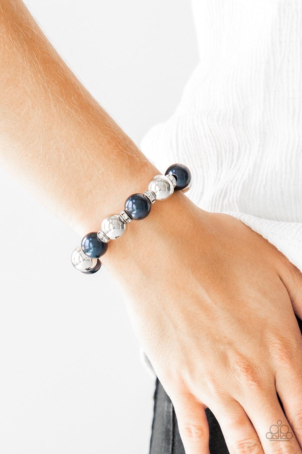 Paparazzi Accessories So Not Sorry - Blue A collection of white rhinestone encrusted rings, blue pearls, and classic silver beads are threaded along a stretchy band around the wrist for a glamorous look. Jewelry