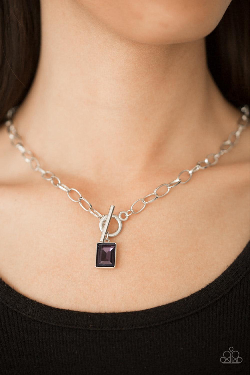 Paparazzi Accessories Wear It Like You Mean It! ~Purple Featuring a regal emerald-style cut, a glassy purple rhinestone is pressed into a sleek silver frame. The glittery frame swings from the bottom of a bold silver chain, creating a glamorous pendant be