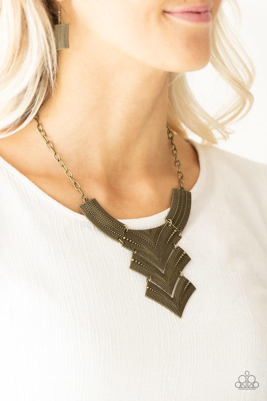 Paparazzi Accessories Fiercely Pharaoh - Brass Radiating in studded details, antiqued brass plates link below the collar, joining into a fierce geometric pendant. Features an adjustable clasp closure.Sold as one individual necklace. Includes one pair of m