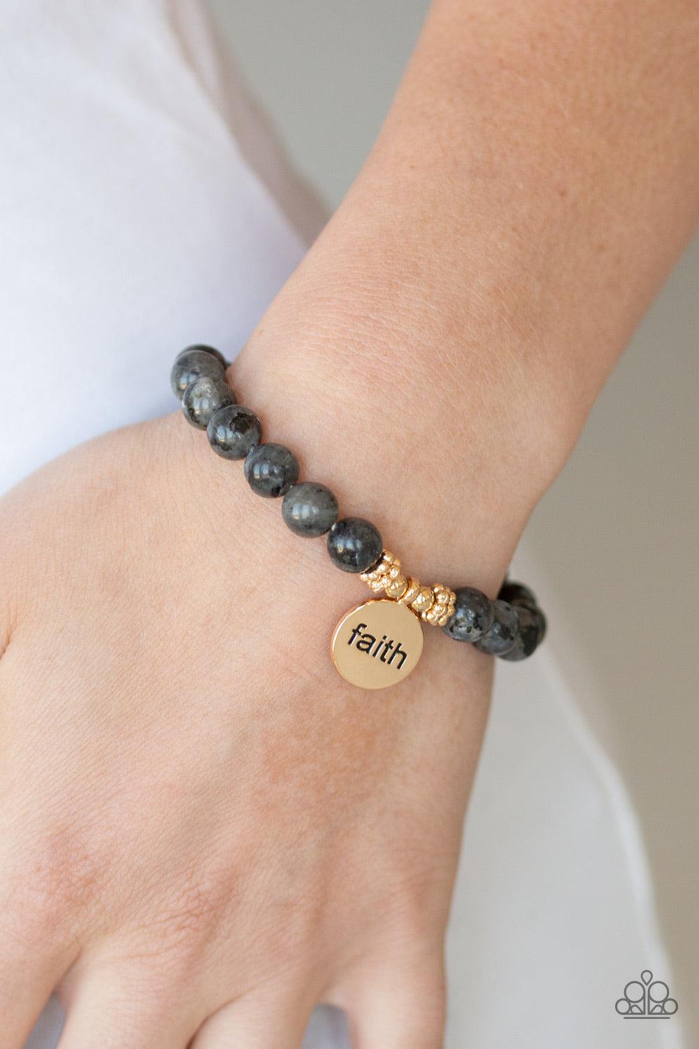 Paparazzi Accessories FAITH It, Till You Make It - Black A collection of glassy black stone beads are threaded along a stretchy band around the wrist for a seasonal flair. A shimmery gold disc stamped in the word, "faith", swings from the wrist for an ins