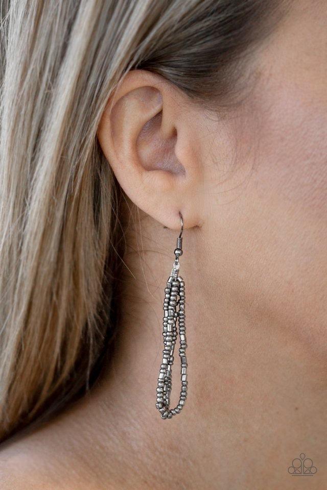 Paparazzi Accessories Dauntless Dazzle - Black Brushed in an icy metallic shimmer, countless strands of gunmetal seed beads drape across the chest in a bold fashion. Featuring a collision of shapes and shimmer, the glittery strands connect to two large gu