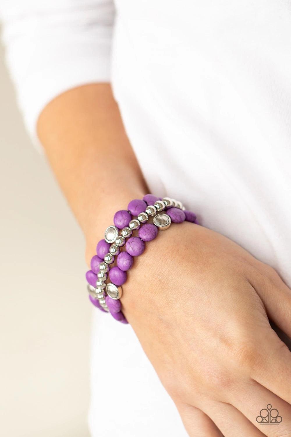Paparazzi Accessories Desert Verbena - Purple A vivacious collection of purple stone beads, ornate silver accents, and classic silver beads are threaded along stretchy bands around the wrist for a seasonally layered look. Sold as one set of three bracelet