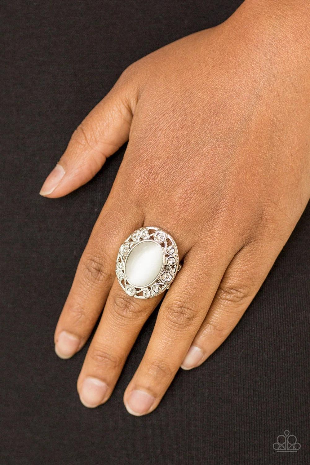Paparazzi Accessories Moonlit Marigold - White Shimmery floral-like filigree swirls around a glowing white moonstone center, creating a whimsical centerpiece atop the finger. Features a stretchy band for a flexible fit. Sold as one individual ring. Jewelr