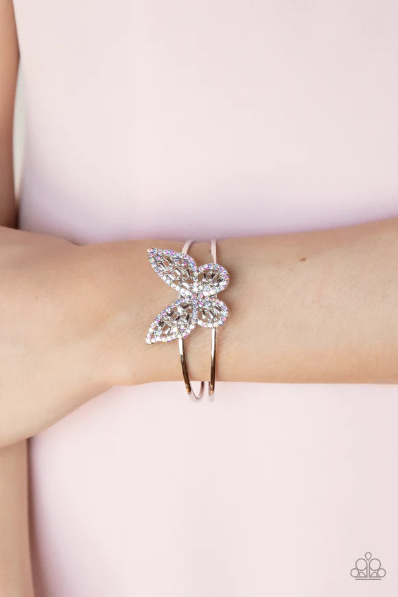 Paparazzi Accessories Butterfly Bella - Multi Bordered in iridescent rhinestones, an airy silver butterfly is dotted in dainty iridescent rhinestones and shiny silver emerald-like accents as it flutters atop a layered silver cuff for an enchanting fashion